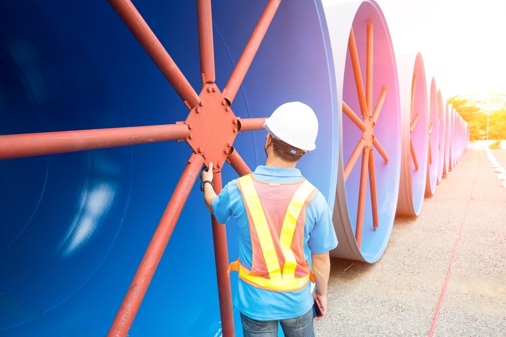 man inspecting roll of mild steel